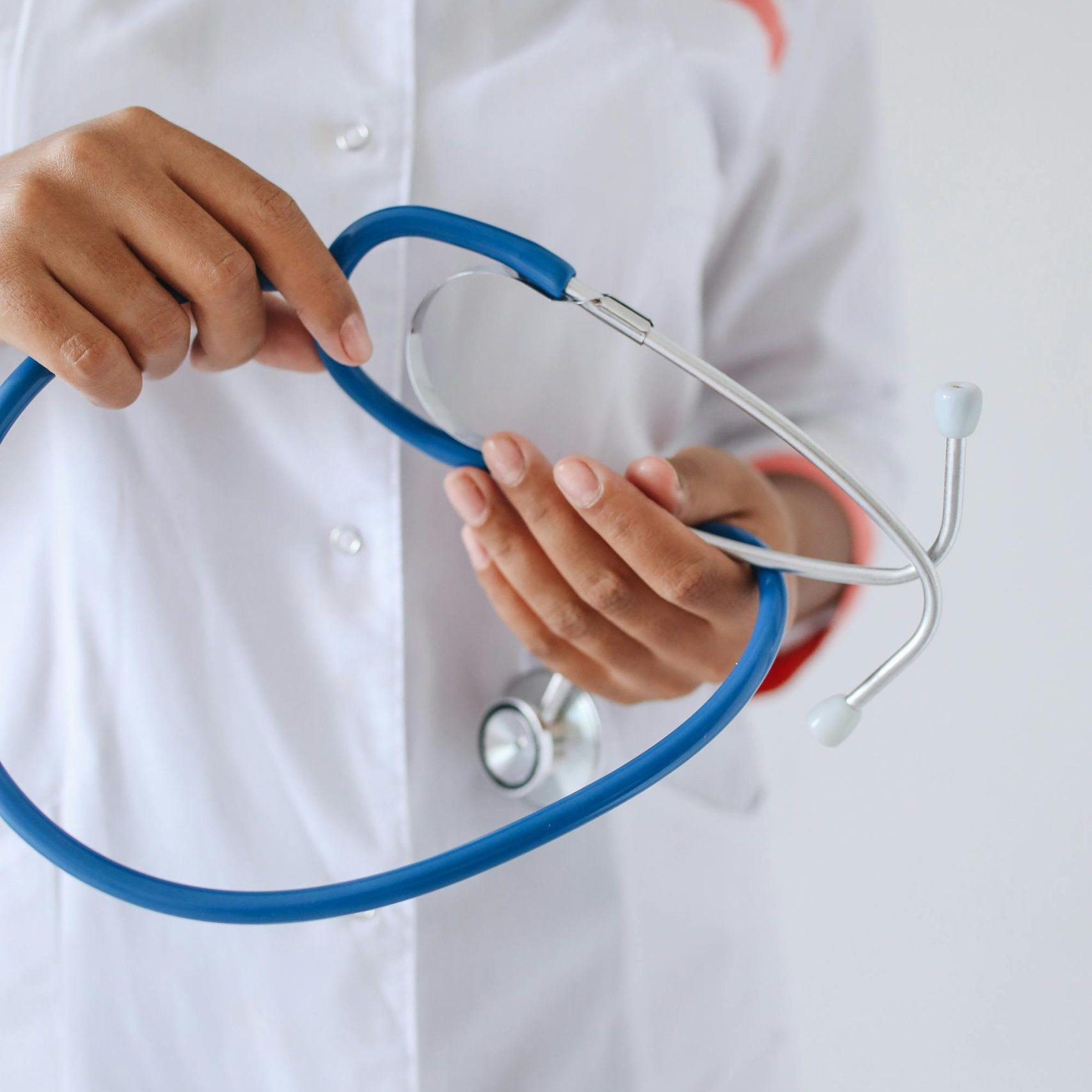 A healthcare professional holding a blue stethoscope, highlighting medical care.