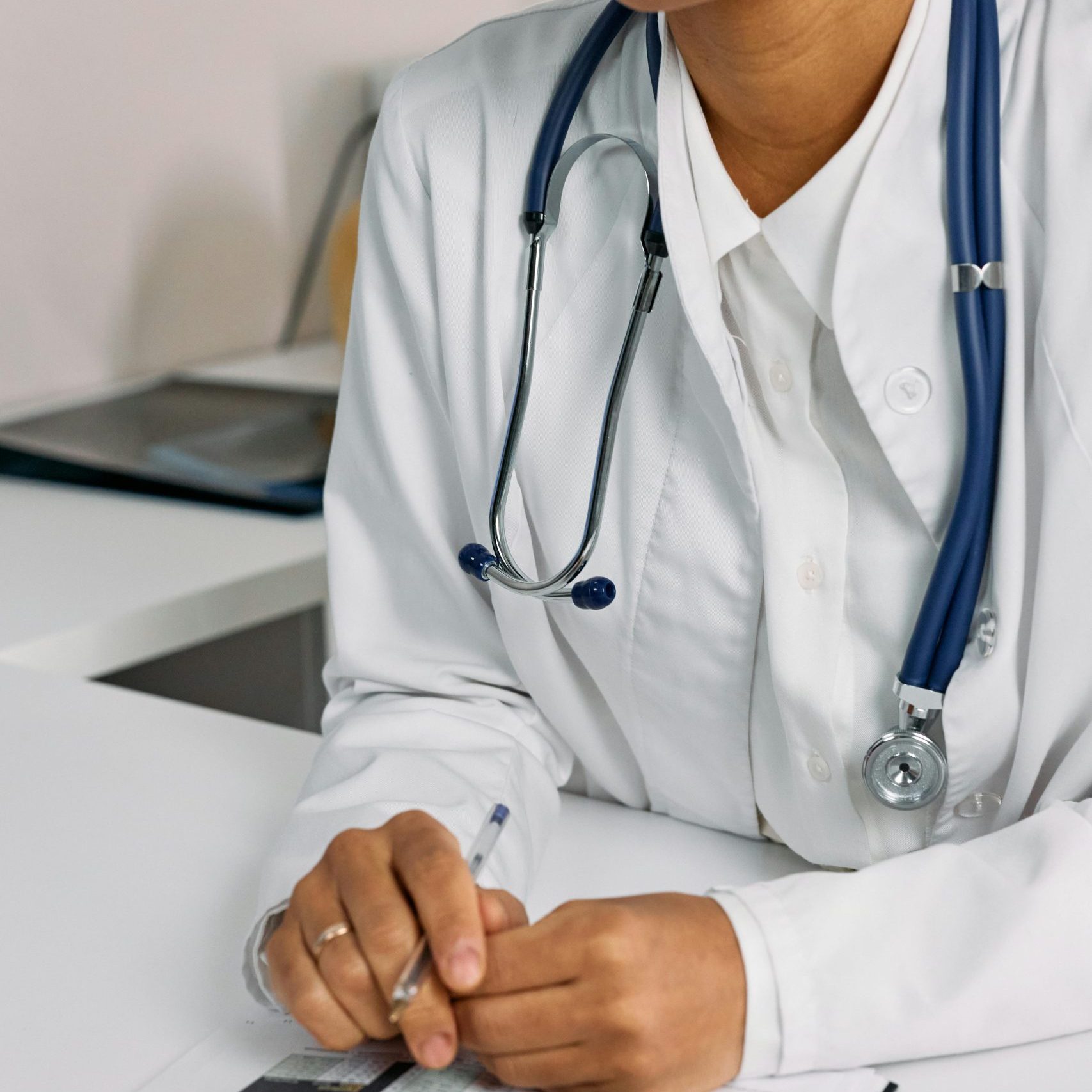 Professional African American female doctor reviewing documents in a clinical setting.